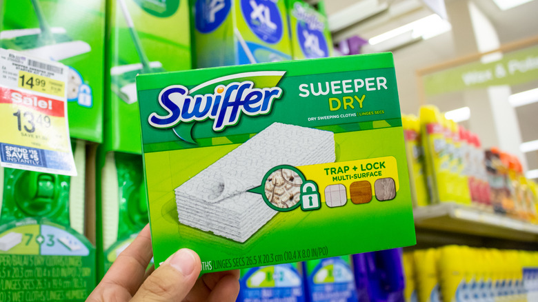 Person holding a box of Swiffer dry cloths in a store