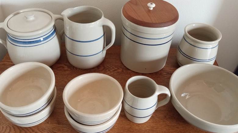 A collection of vintage white and blue Marshall Pottery dishware on a wooden table