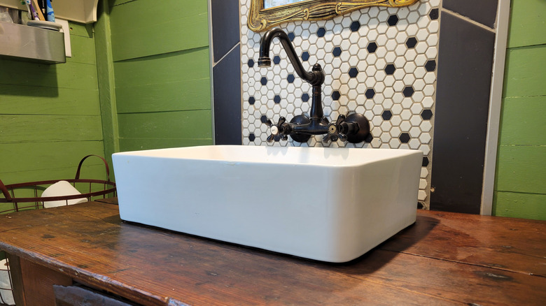Rustic bathroom vanity DIYed from a thrift store biscuit table find from the side