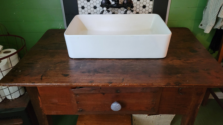 Rustic bathroom vanity DIYed from a thrift store biscuit table find from the front