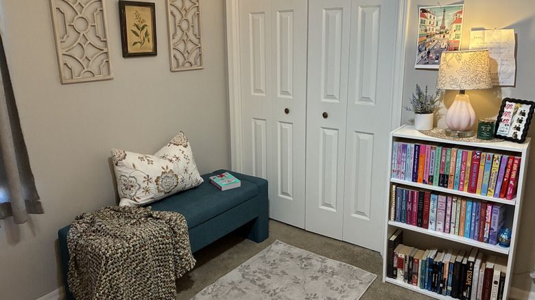Finished DIY reading nook with a bookcase, storage bench, and wall art