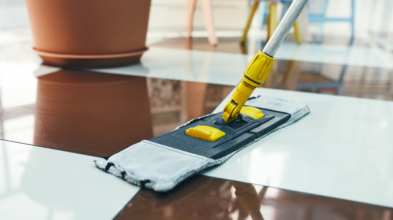 person mopping checkered tile floor