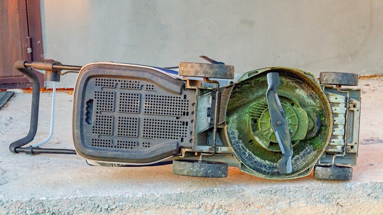 Lawn mower tipped on its side exposing the undercarriage