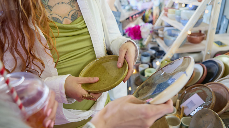 Two women shopping for vintage kitchenware products at a thrift store.