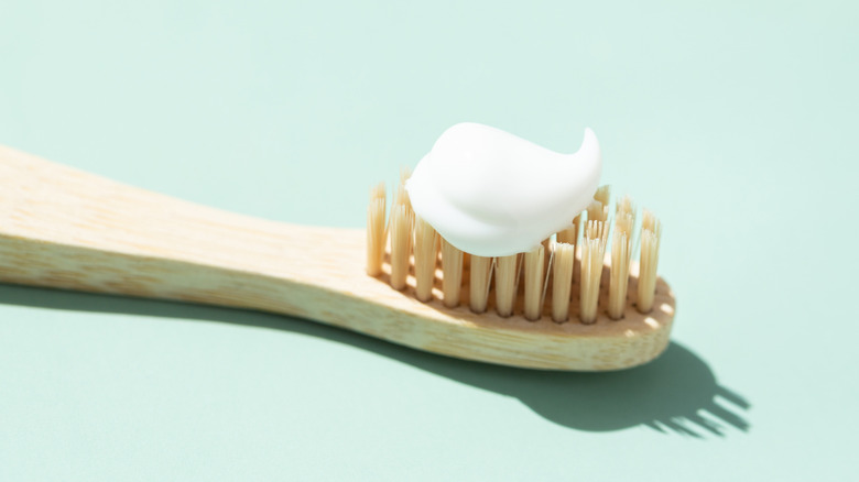 closeup of white toothpaste on a wooden toothbrush