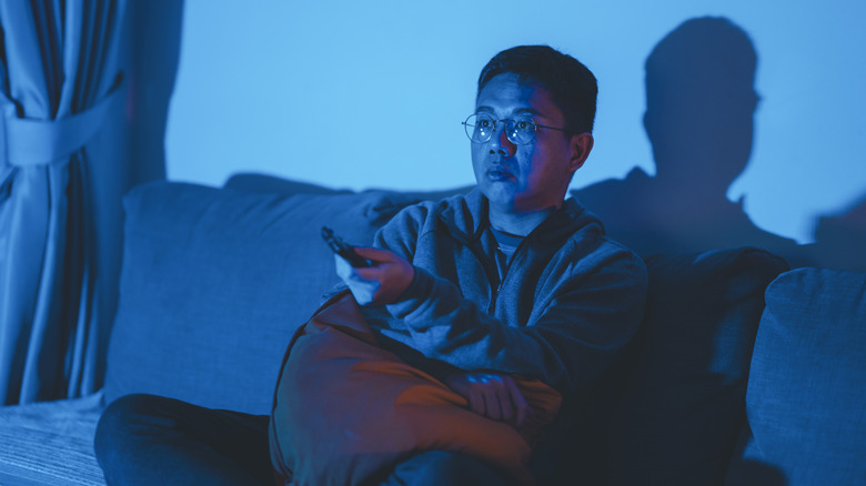 Man watching TV in blue light