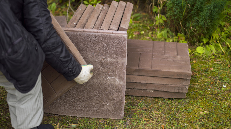 person lifting patio pavers