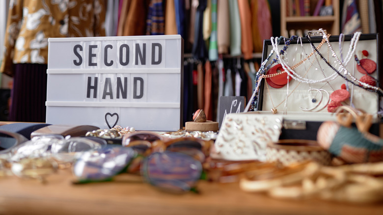 thrift store with second hand sign and displayed clothes and jewelry