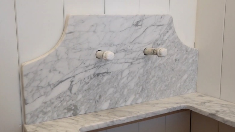 A curved sink backsplash being installed