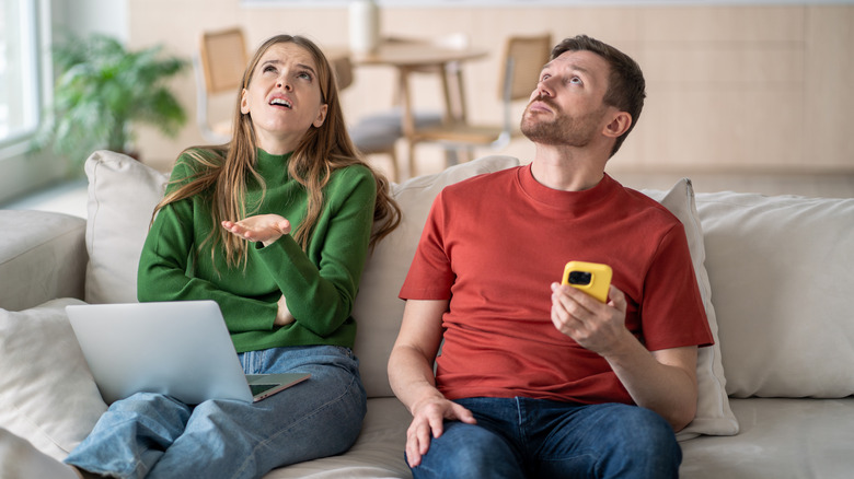 Frustrated couple looking up at the ceiling