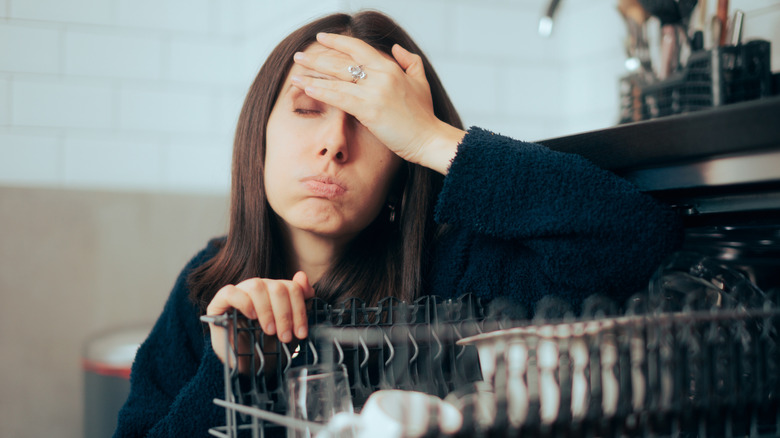 Frustrated woman dealing with dishwasher problems