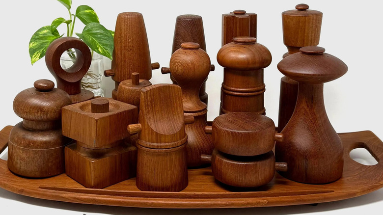 A collection of Dansk pepper mills by Jens Quistgaard on a wooden tray