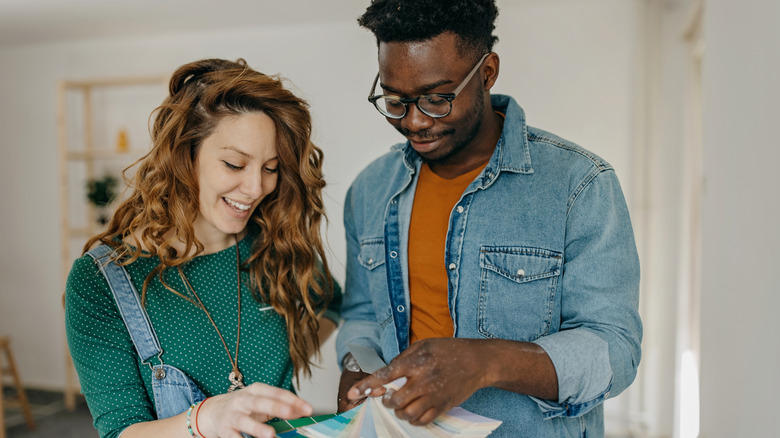 Two people looking through paint swatches