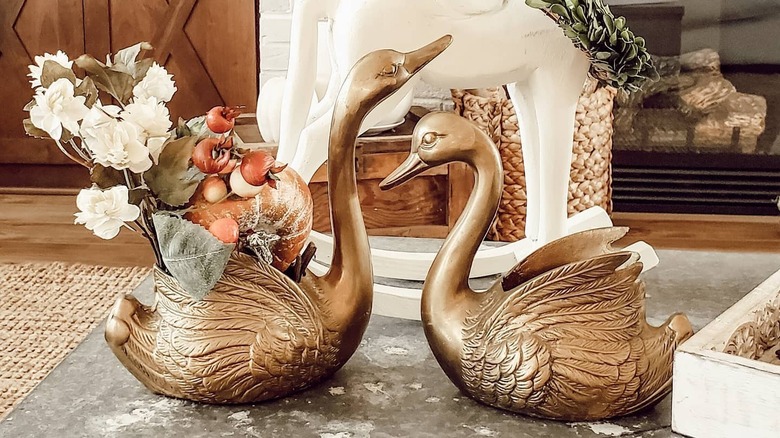 Brass swan planters on a coffee table