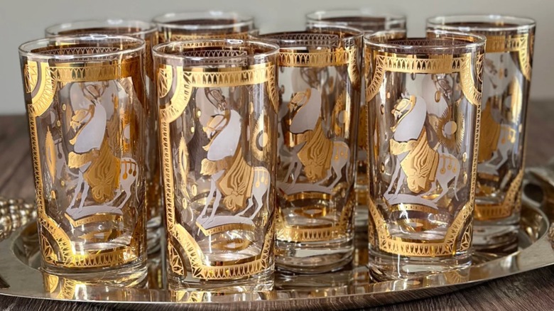 Vintage Fred Press highball glasses decorated with gold horses and placed on a silver tray