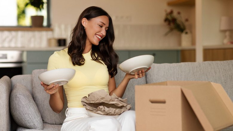 A woman excitedly unboxes two dishes