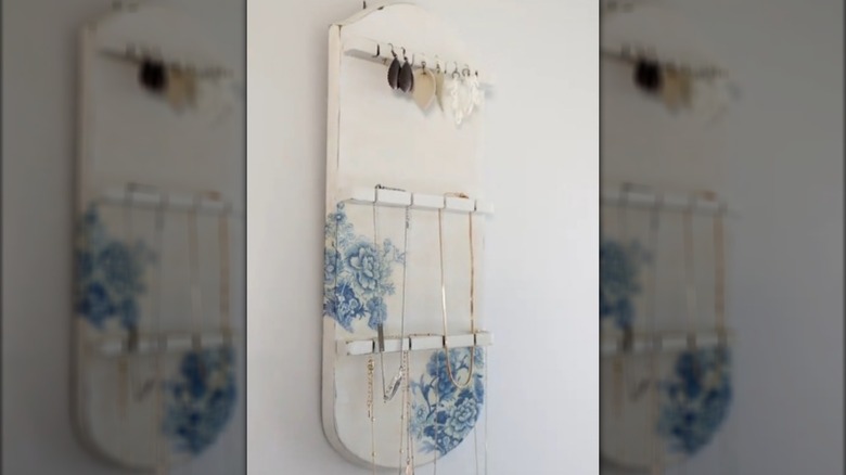 a white spoon rack with jewelry draped on it