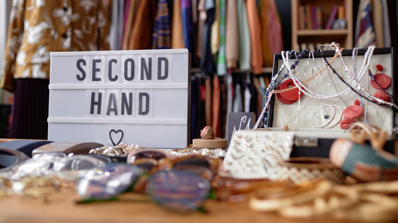 Thrift store display with sign that spells out "second hand"