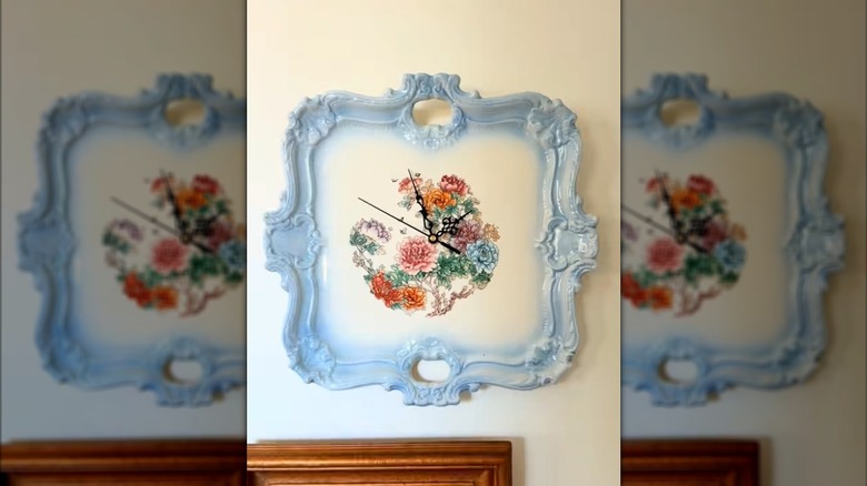 Vintage serving tray with blue edges and a floral design with serpentine-style clock hands