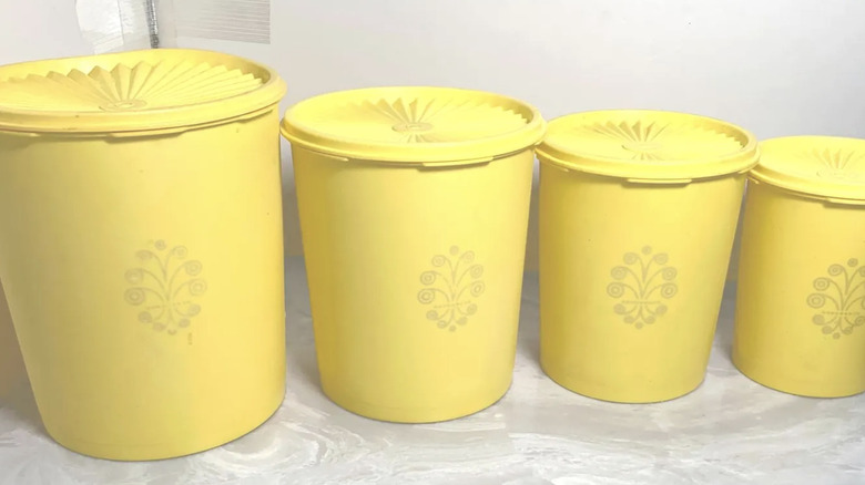 A set of four gold Servailer Tupperware containers