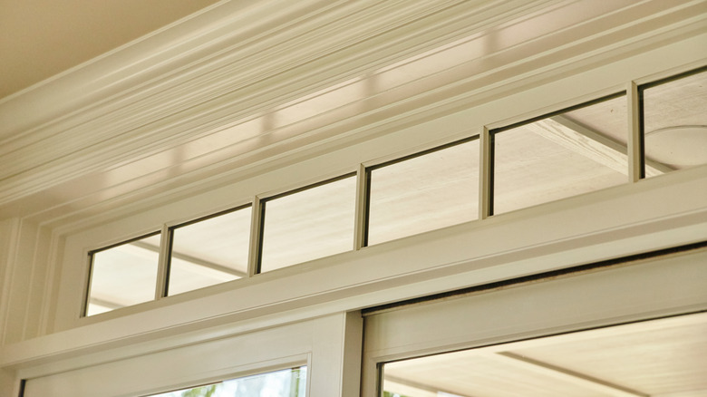 Interior transom window surrounded by white crown molding