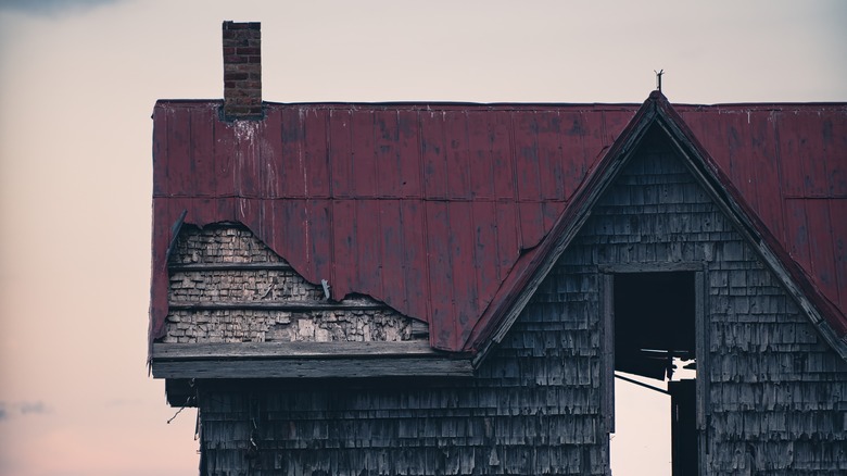 An abandoned old house with a rusted metal roof