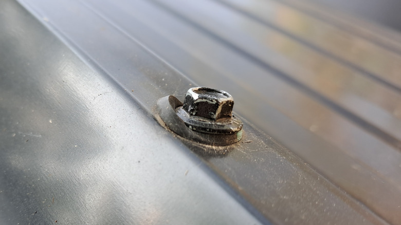 A screw with integrated washer for use with corrugated metal roofs