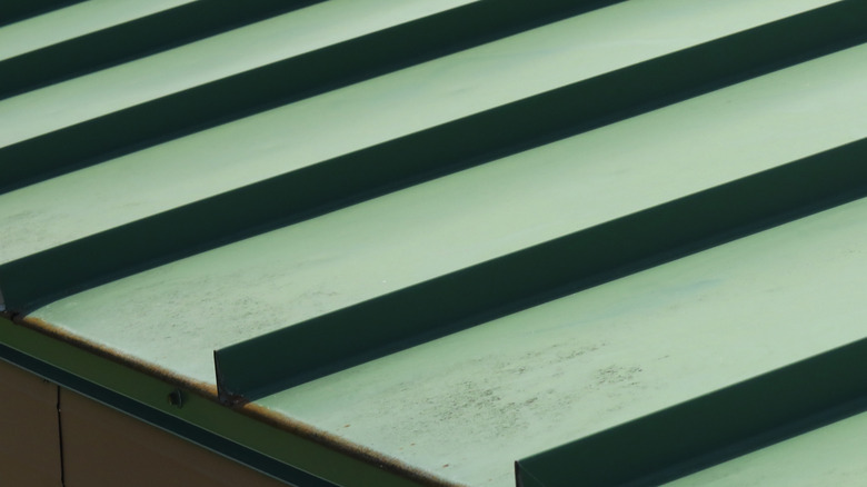 Rust showing at the edges of a poorly coated standing-seam roof