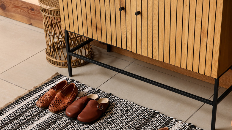 Shoes in front of shoe cabinet in front hallway