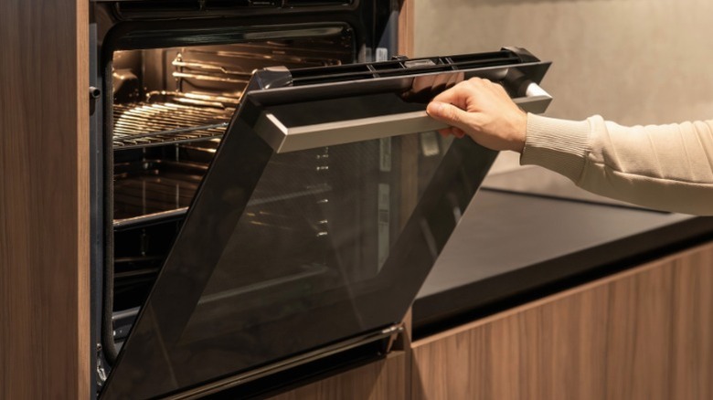 Person open wall oven door