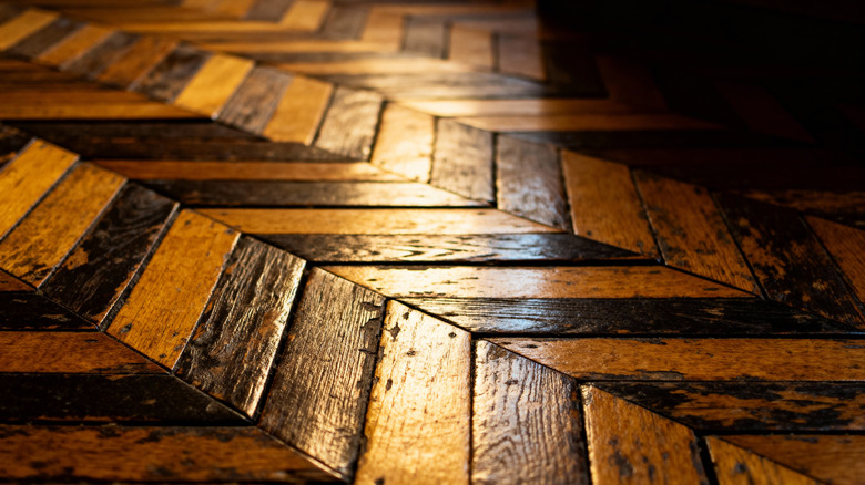 Closeup of vintage dark and light wood floor set in a Herringbone pattern.
