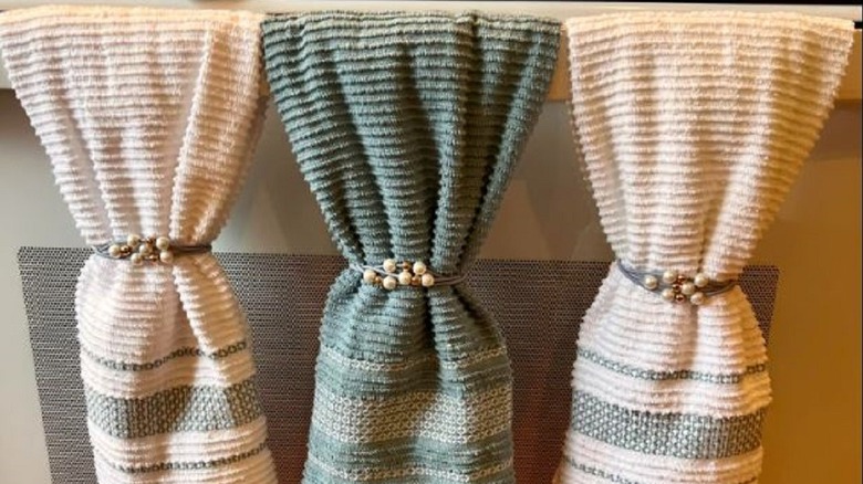 Kitchen towels hung on oven handle with hair ties