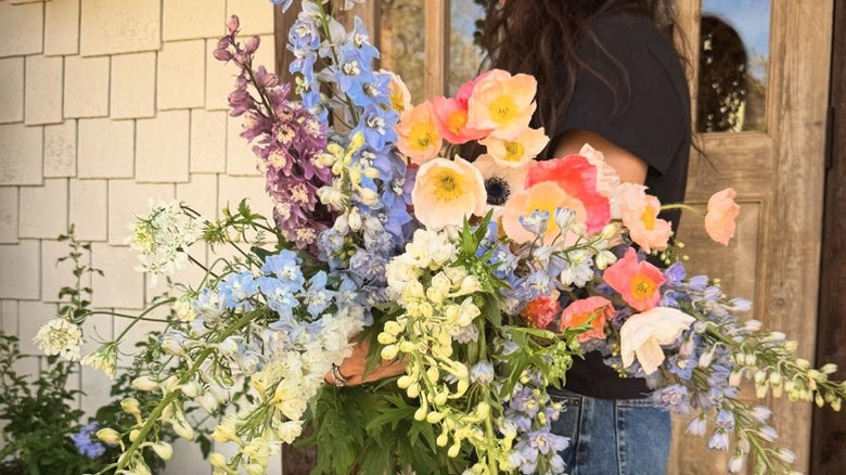 Joanna Gaines with an armful of fresh delphinium and poppy flowers