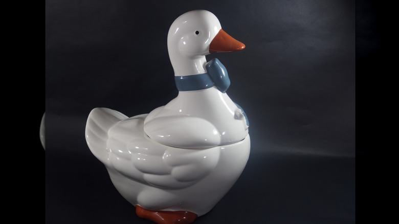 A country geese cookie jar with a blue-gray bow around its neck