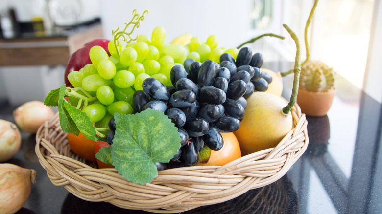 A faux fruit basket in a kitchen's window