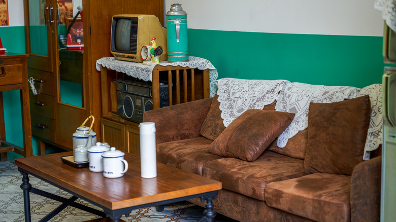 A 1980-style living room with dated carpets, decor, and furniture