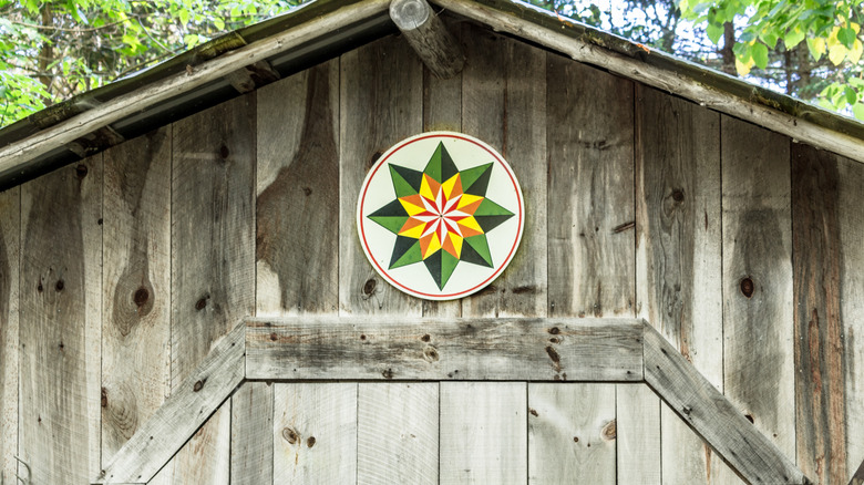 a traditional barn star or hex sign on a small outbuilding