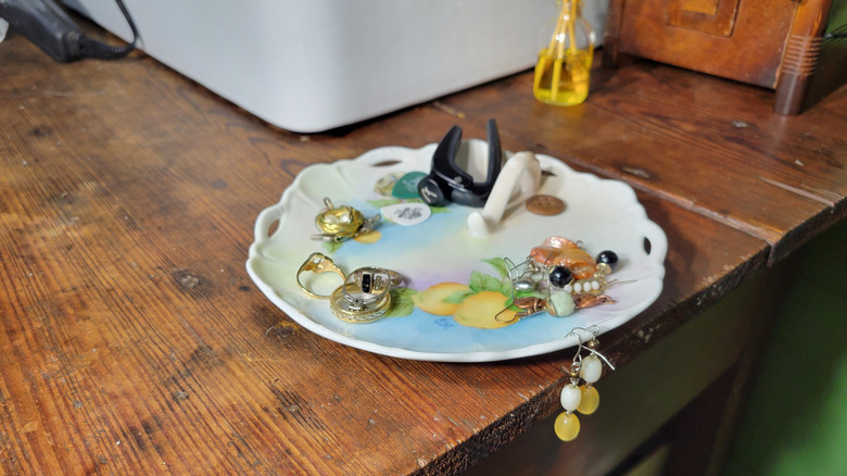 A thrifted candy dish used to keep clutter managed on a bathroom vanity