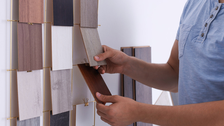 Man looking at wood flooring color options in a store
