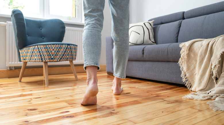Person walking on light colored wood flooring