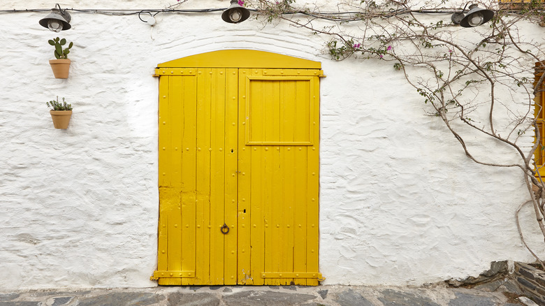 bright yellow door in on stone building facade
