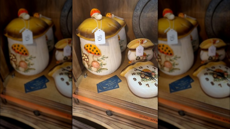 Vintage Merry Mushroom canisters priced in wood art deco cabinet at estate sale