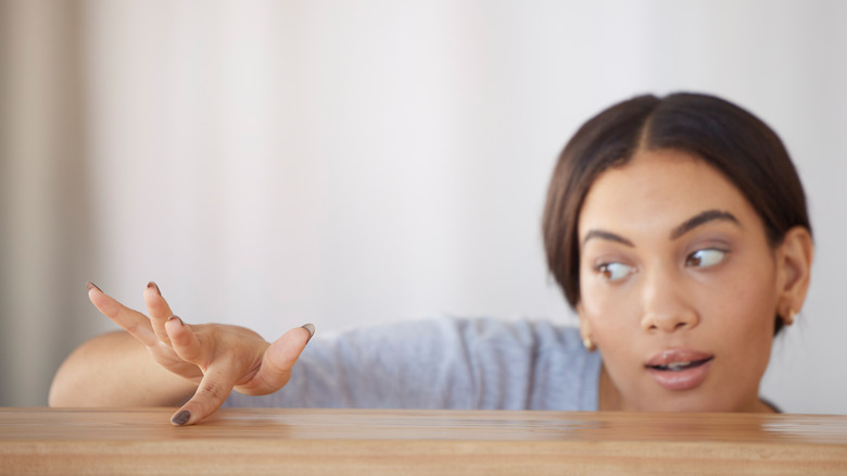 Woman dragging finger across table top