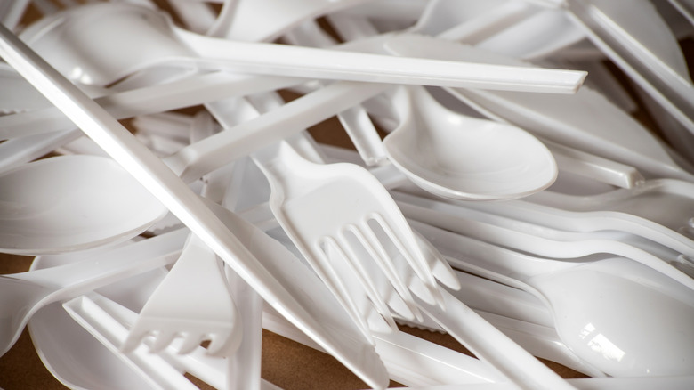 A pile of disposable plastic forks and spoons