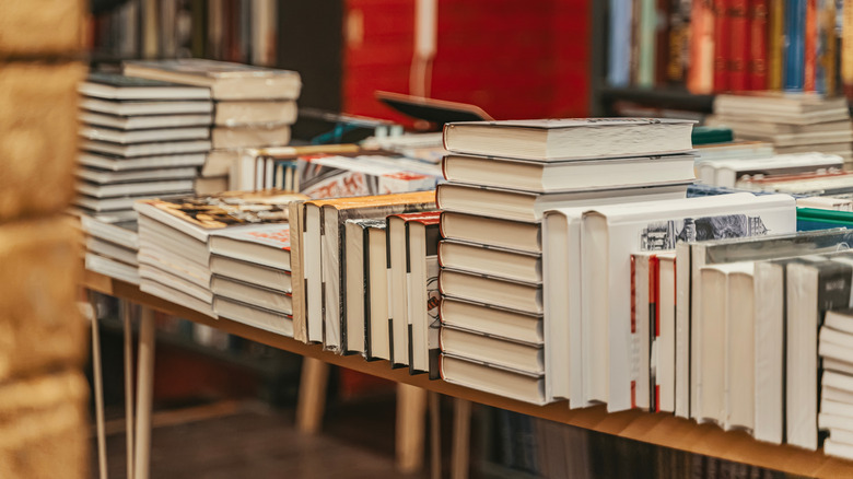 Stacks of hardcover books lined up on a table