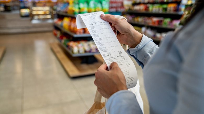 Person holding a store receipt in their hands