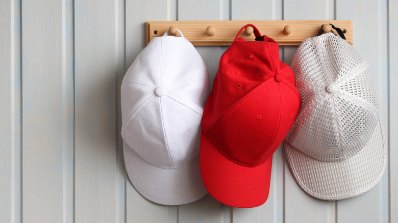 Three baseball hats hanging on wall