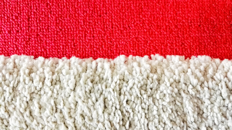 High-pile white carpet next to low-pile red carpet close-up