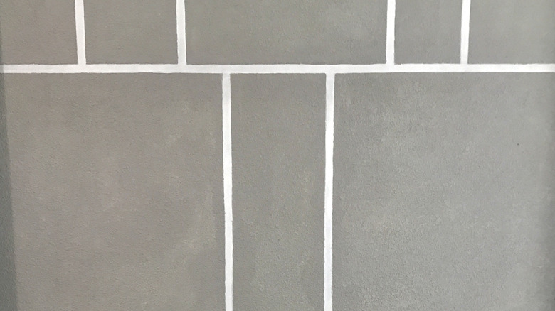 Unsealed gray tile and white grout lines
