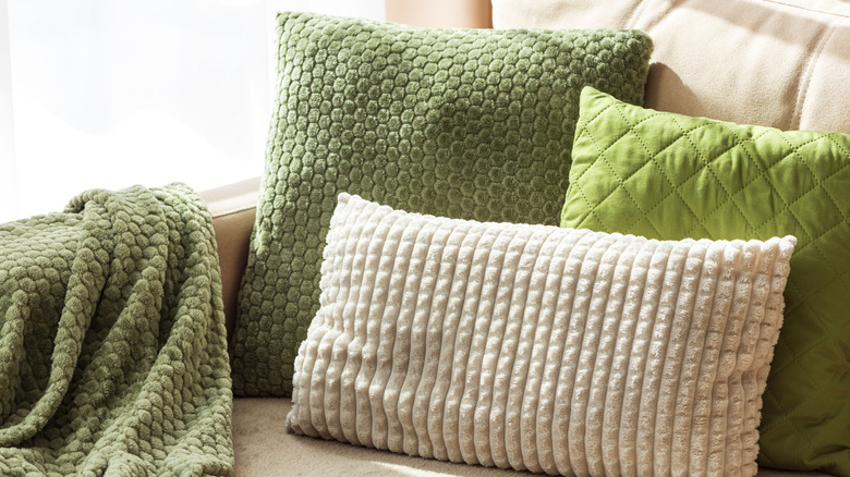 Green and pink decorative pillows on a couch